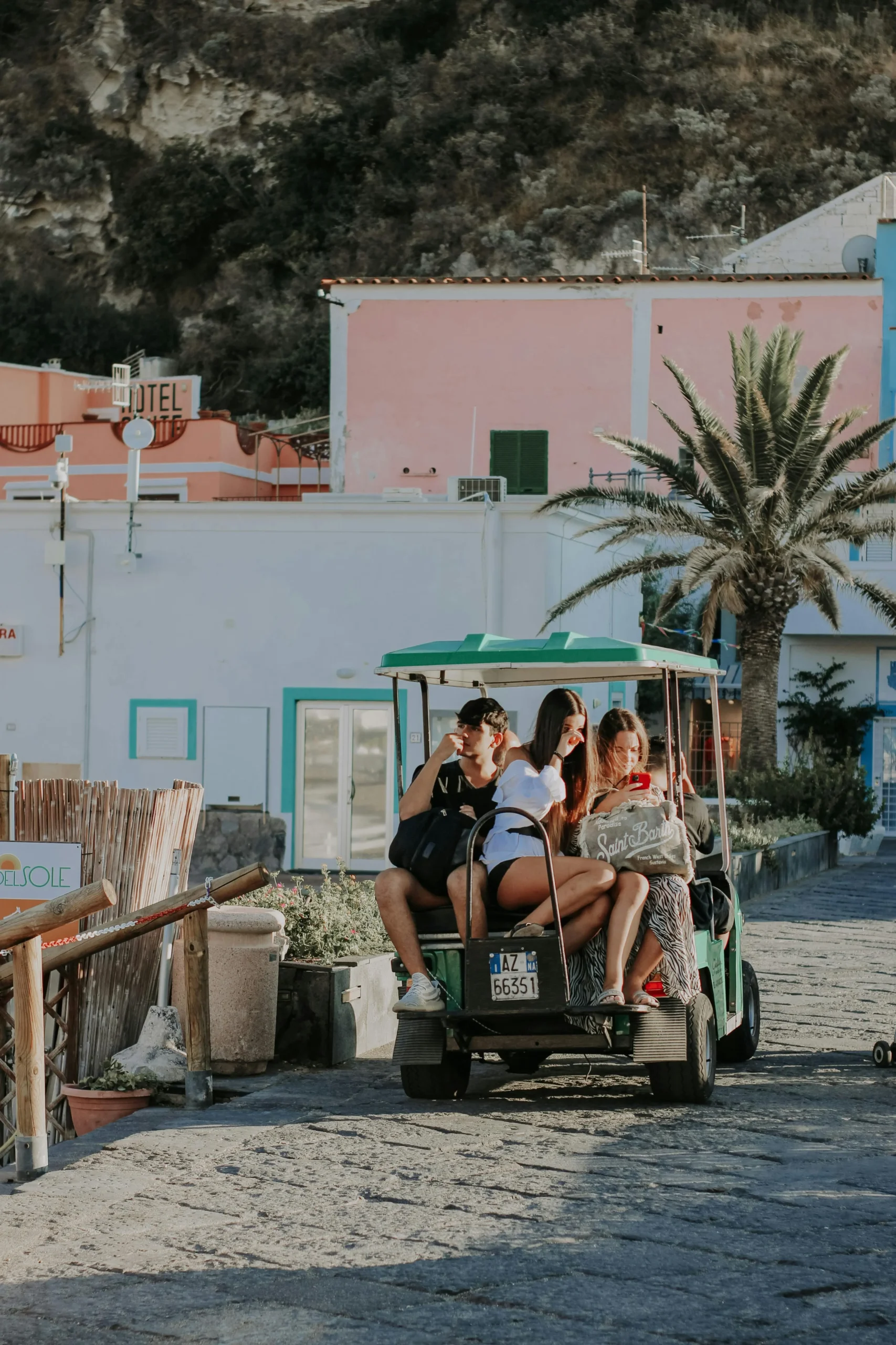 Grupo de jóvenes disfrutando de un paseo en un carrito de golf eléctrico verde en un destino turístico mexicano.